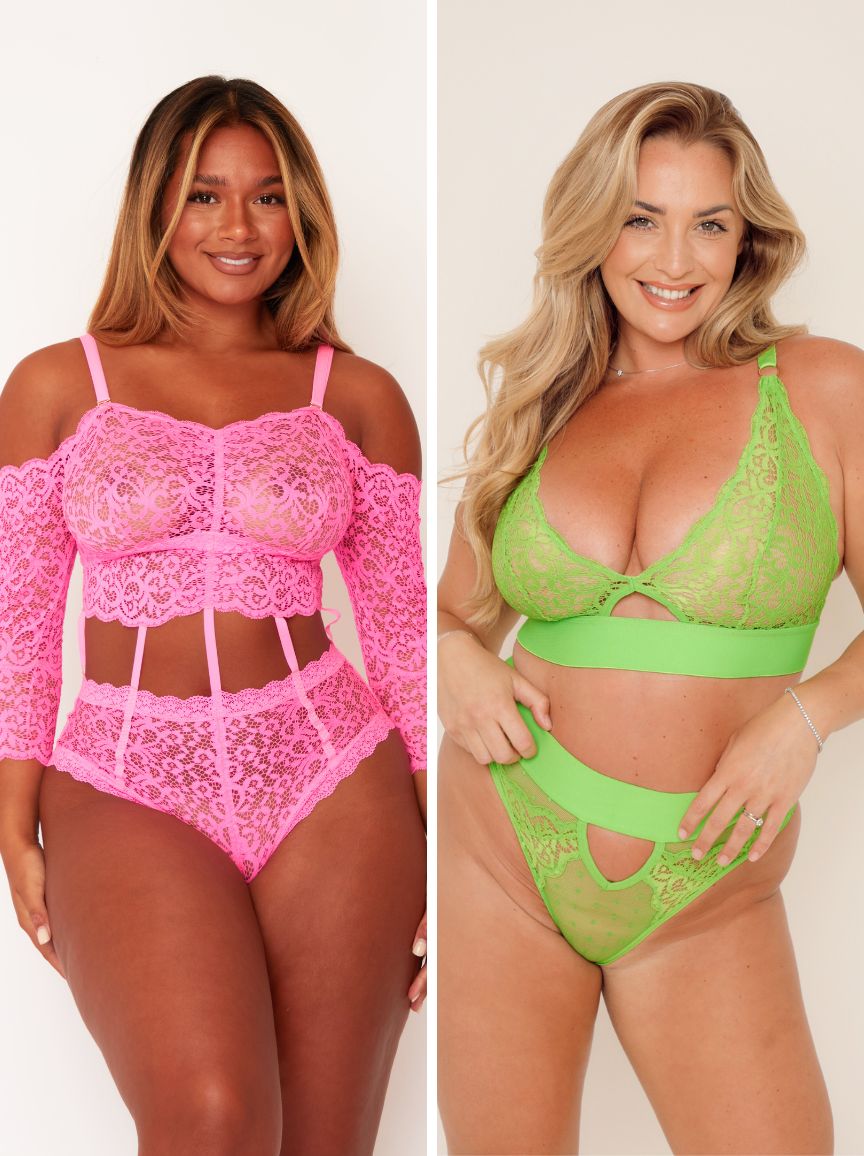 Two women wearing pink and green lace lingerie sets on a plain background